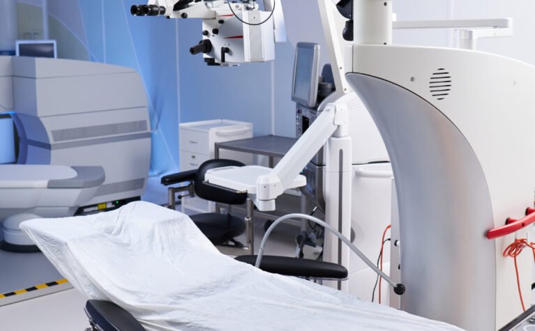 Empty operating room featuring advanced surgical microscope and covered operating table, showcasing modern medical equipment and technology prepared for surgical procedure